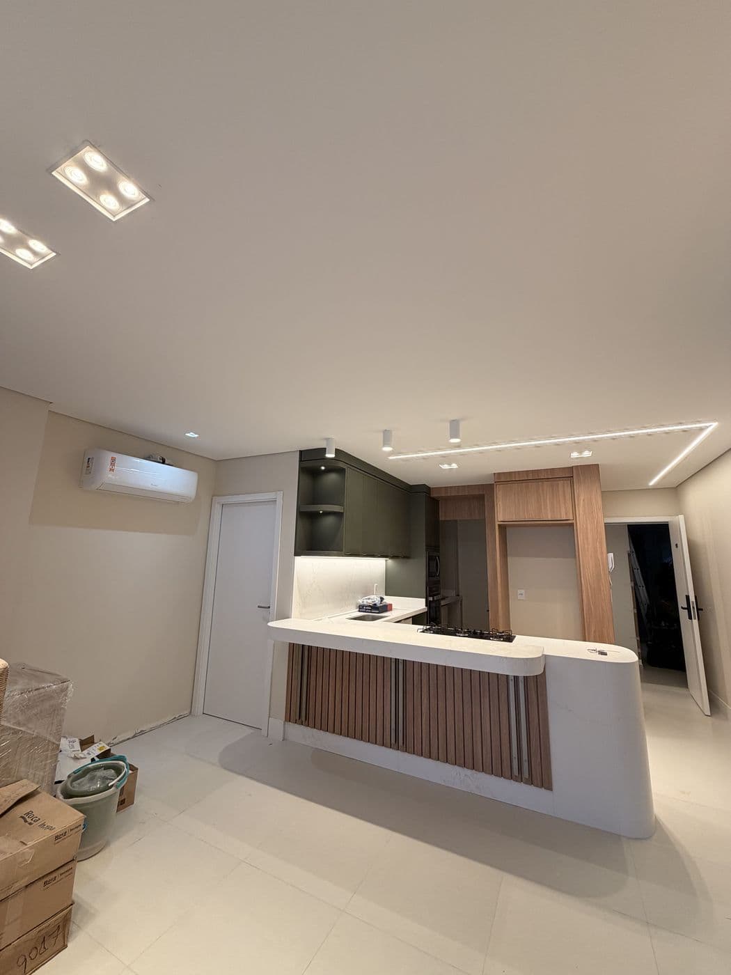 Balcão com painel ripado iluminado e perfis no teto