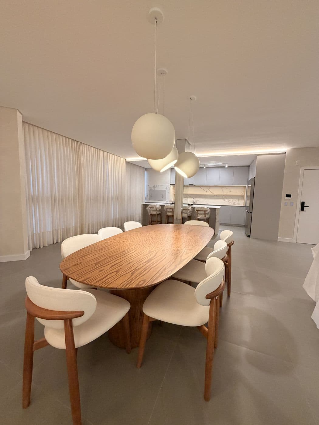 Sala de jantar com pendentes de esferas e cortinas
