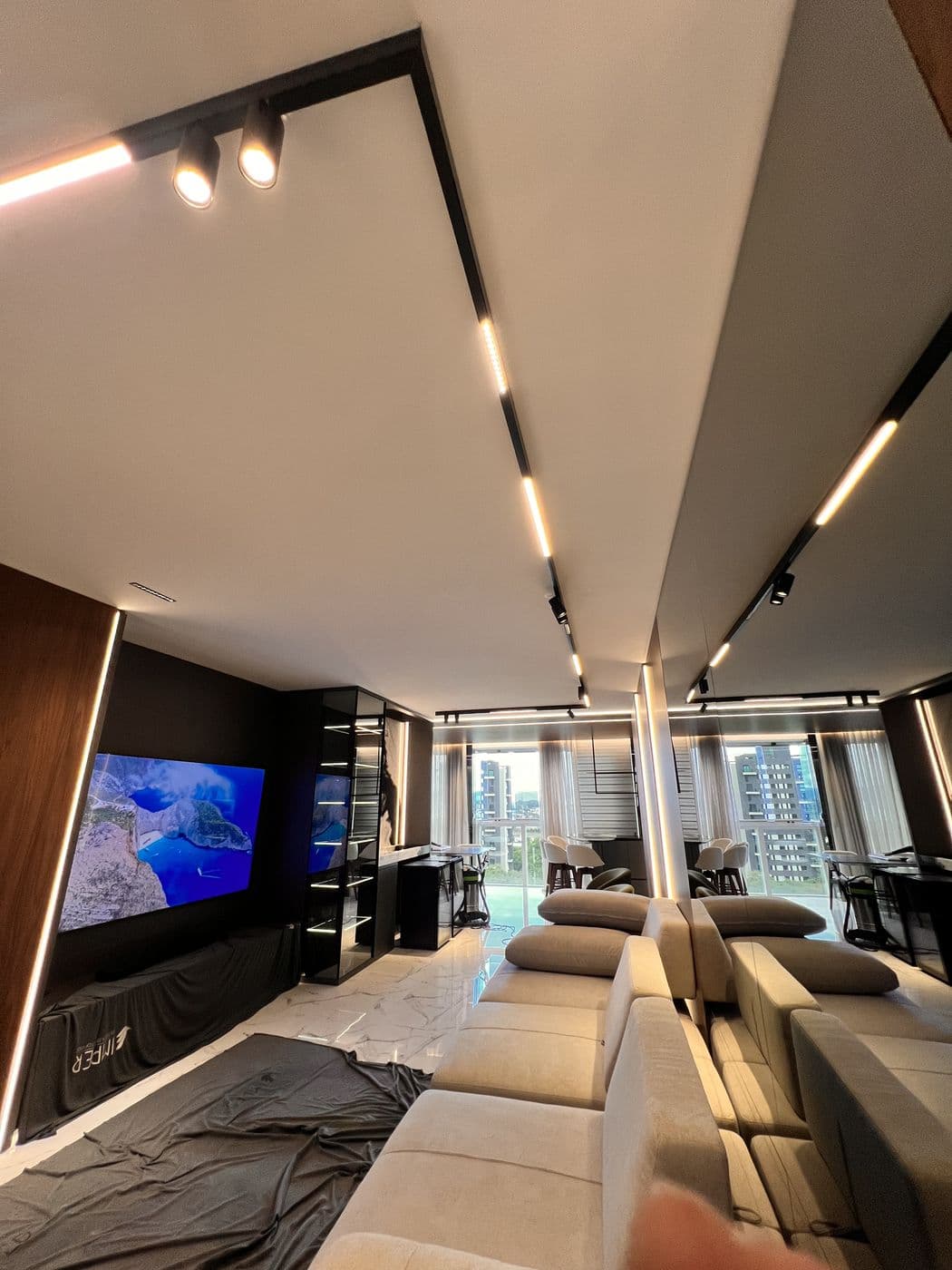 Sala com trilho de spots e painel de TV